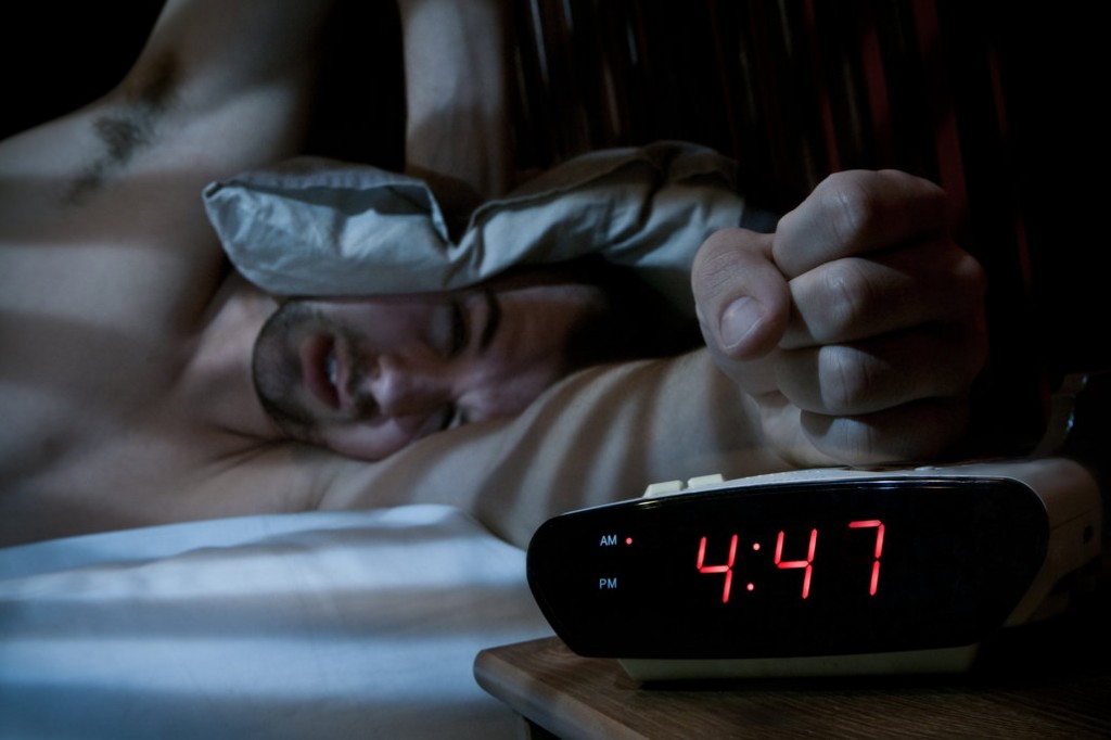 Unhappy man smashing the alarm clock.